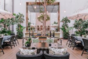 a restaurant with tables and chairs and trees at Casa Polanco Hotel Boutique in Mexico City