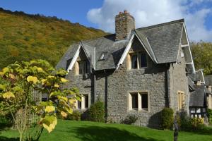 uma velha casa de pedra num relvado verde em The School House B & B em Bucknell