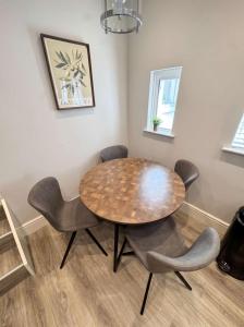 a dining room with a wooden table and chairs at Bright 2-Bed Garden Flat Central Guildford in Purley