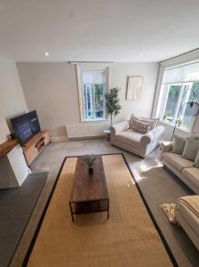 a living room with a couch and a coffee table at Bright 2-Bed Garden Flat Central Guildford in Purley