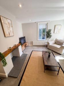 a living room with a couch and a table at Bright 2-Bed Garden Flat Central Guildford in Purley +13 photos