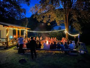 a group of people sitting around a fire at night at Дім з видом на гори. in Vizhenka