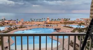 a view of the pool from the balcony of a resort at ساوث بيتش بورتو السخنه in Ain Sokhna