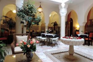 een lobby met tafels en stoelen en een fontein bij Riad Nirvana in Marrakesh