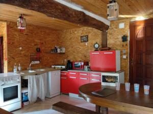 a kitchen with red cabinets and a red refrigerator at Le Mont Rochard in Sainte-Gemmes-le-Robert