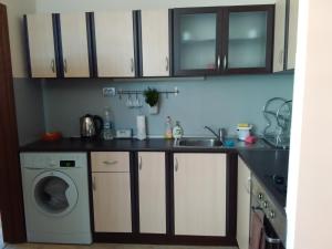 a kitchen with a sink and a washing machine at Geri Apartment in Burgas City
