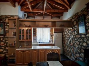 a kitchen with wooden cabinets and a window at Ktima Lazarata in Lazaráta