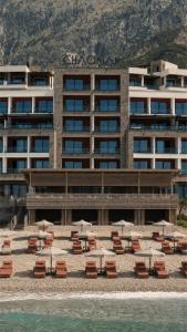 a large building with chairs and tables on a beach at Chaonian Hotel in Dhërmi