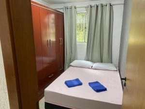a bedroom with a bed with two blue towels on it at Apartamento térreo bem equipado, fácil acesso in Canoas