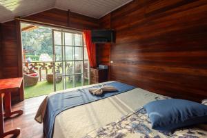 a bedroom with a bed with wooden walls and a window at QUINTA PRIMAVERA - Hostería Campestre in Nueva Loja +56 photos