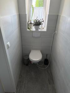 ein kleines Badezimmer mit Toilette und Fenster in der Unterkunft Schmidt Pension in Karstädt