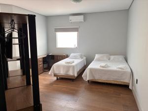 a bedroom with two beds and a window at Fully equipped house - 7 guests in Petrolina