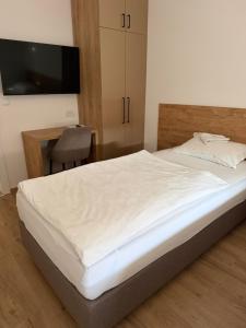 a bedroom with a bed with a desk and a television at Premium in Negotin
