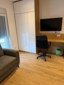 a living room with a chair and a flat screen tv at Premium in Negotin