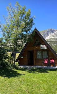 a log cabin with two chairs in front of it at Guest House Višnja in Žabljak