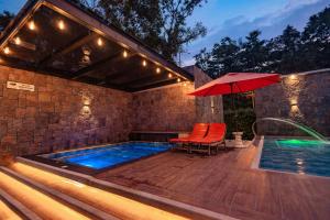 a swimming pool with an umbrella and a table and chairs at QUINTA PRIMAVERA - Hostería Campestre in Nueva Loja