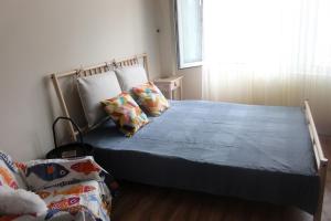 a bedroom with a bed with a blue comforter and a window at Saltywind House in Pomorie +6 photos