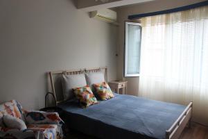 a bedroom with a blue bed and a window at Saltywind House in Pomorie