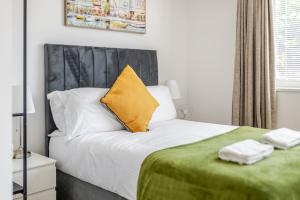 a bedroom with a bed with a yellow pillow on it at Central 1BR Flat Full Kitchen & Washing Machine in Andover