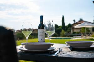 a table with a bottle of wine and two glasses at Entire house for couple with exclusive pool in Monsanto