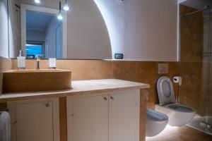 a bathroom with a sink and a toilet and a mirror at Entire house for couple with exclusive pool in Monsanto +27 photos