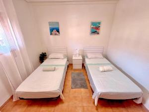 a room with two beds in a room at SiCasa Punta Prima in Punta Prima