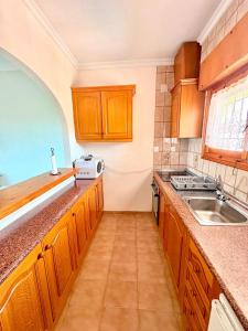 a kitchen with wooden cabinets and a sink at SiCasa Punta Prima in Punta Prima +4 photos