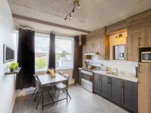 a kitchen with a table and a sink and a window at Lofts Orizon in Rimouski