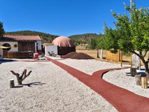 ein roter Weg, der zu einem Gebäude mit einer Kuppel führt in der Unterkunft Burbuja Glamping AntiSaturno - Casas del Alto Tajo in Ablanque