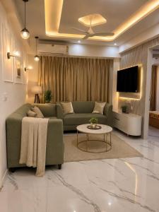 a living room with a green couch and a table at Gurgaon Legacy in Gurgaon
