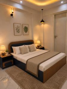 a bedroom with a large bed with two tables and two lamps at Gurgaon Legacy in Gurgaon +12 photos