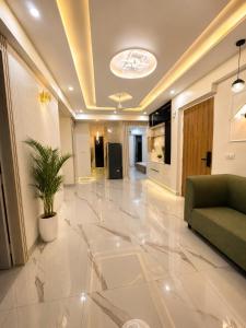 a lobby with a couch and a potted plant at Gurgaon Legacy in Gurgaon