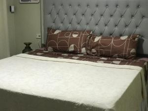 a bed with brown and white sheets and pillows at Carib Ochi Rios condominium in Ocho Rios