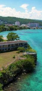 an island in the middle of the water with a building at Carib Ochi Rios condominium in Ocho Rios