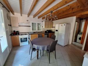a kitchen with a table and chairs and a refrigerator at Gite de la véore in Chabeuil