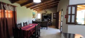 a dining room with a red table and chairs at Cálida Casa con amplio espacio verde en Raco in Raco