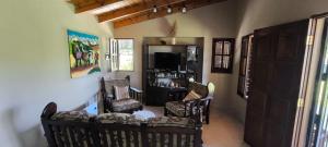a living room filled with chairs and a tv at Cálida Casa con amplio espacio verde en Raco in Raco