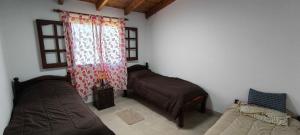 a bedroom with two beds and a window at Cálida Casa con amplio espacio verde en Raco in Raco