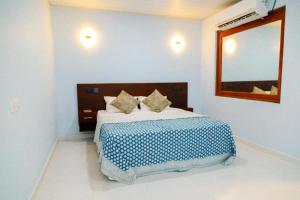 a bedroom with a bed with a blue and white blanket at Midtown Mansion in Veyangoda