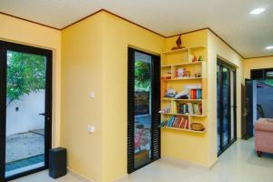 a room with a yellow wall with a book shelf at Midtown Mansion in Veyangoda