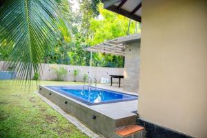 a swimming pool in the backyard of a house at Midtown Mansion in Veyangoda +29 photos