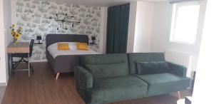 a bedroom with a bed and a couch and a table at Chambre avec grande terrasse privative in Aurillac