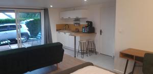 a kitchen and living room with a car parked outside at Chambre avec grande terrasse privative in Aurillac