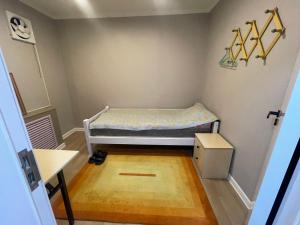 a small bedroom with a bed and a wooden floor at Suu Hostel Downtown in Ulaanbaatar