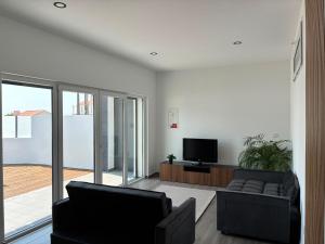 a living room with two couches and a television at Villa Pérola Pestana in Lourinhã