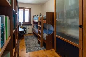 a dorm room with bunk beds and a desk at I Monelli in Sestola