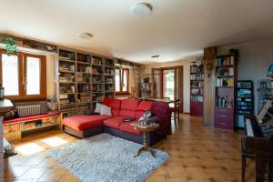 a living room with a red couch and book shelves at I Monelli in Sestola