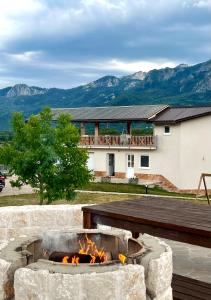 a fire pit in front of a building with mountains at Monte Escape Village in Šavnik