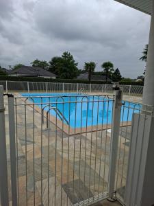 a swimming pool behind a fence with a slide at Résidence Le Soleil de Nousty in Nousty