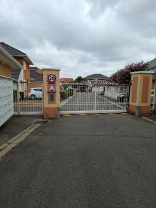 a gate with a speed limit sign in front of a house at Résidence Le Soleil de Nousty in Nousty